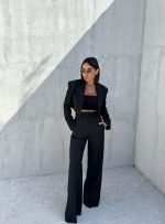 Crno trendi odelo sa kraćim blejzerom i zvonastim pantalonama visokog struka