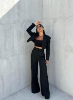 Crno trendi odelo sa kraćim blejzerom i zvonastim pantalonama visokog struka