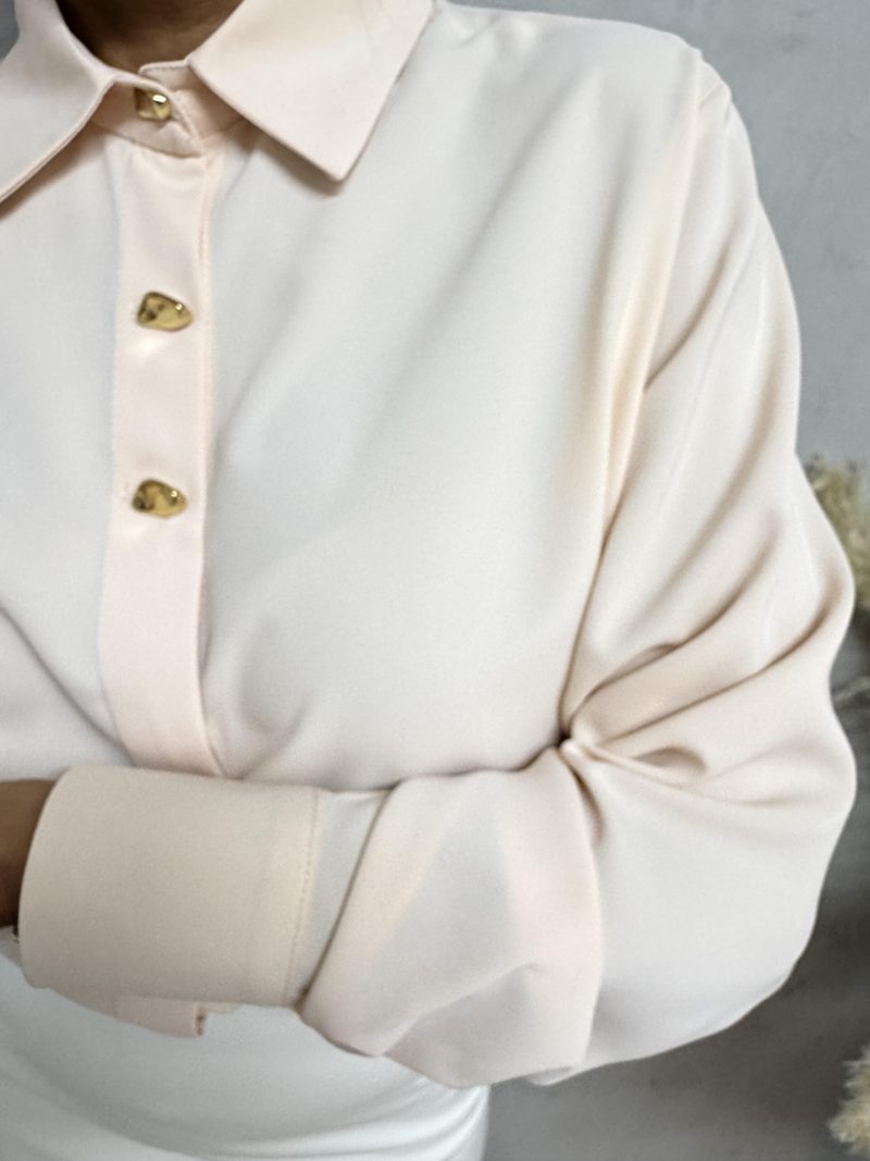 Elegantna košulja sa zlatnim dugmadima nežne pastelne boje kajsije