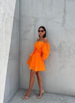 Mini narandžasta pamučna boho haljina sa vezenim detaljima otkrivenih ramena i tri četvrt rukava na kopčanje sa pojasom