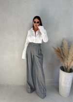 Sive zvonaste pantalone visokog struka, naglašenog pojasa, podvijenih nogavica
